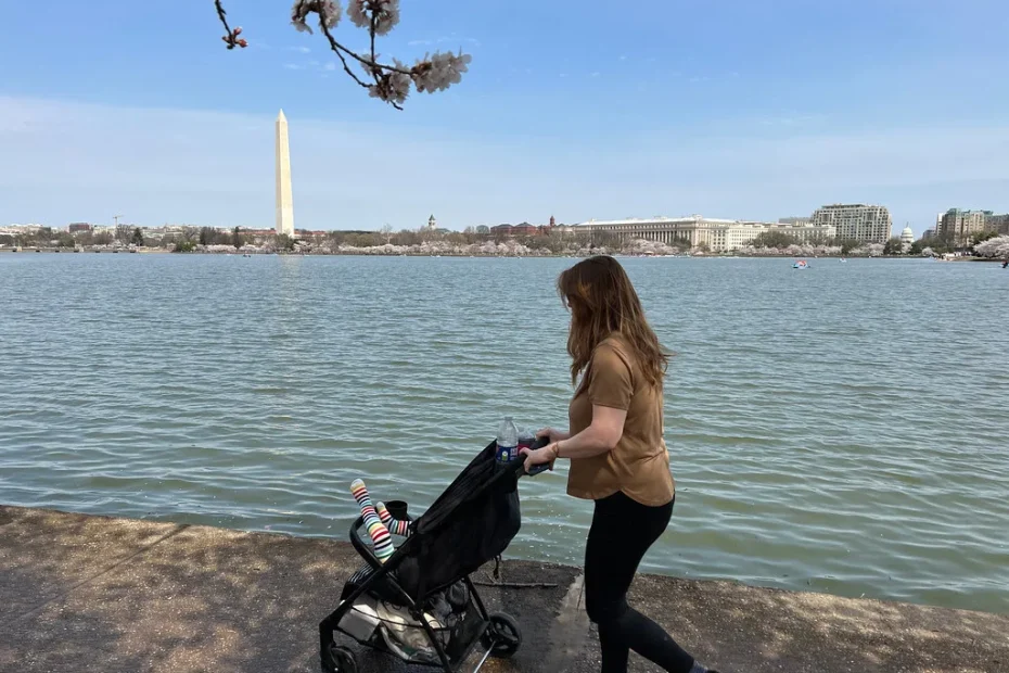 Parent marchant à côté de son enfant qui fait ses premiers pas en extérieur