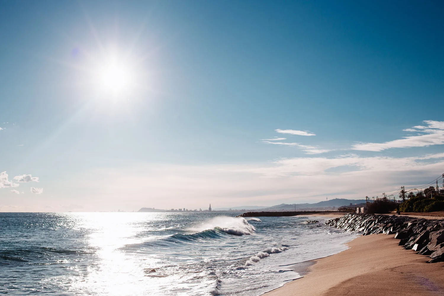 Belle plage méditerranéenne avec vagues douces et soleil éclatant en bord de mer