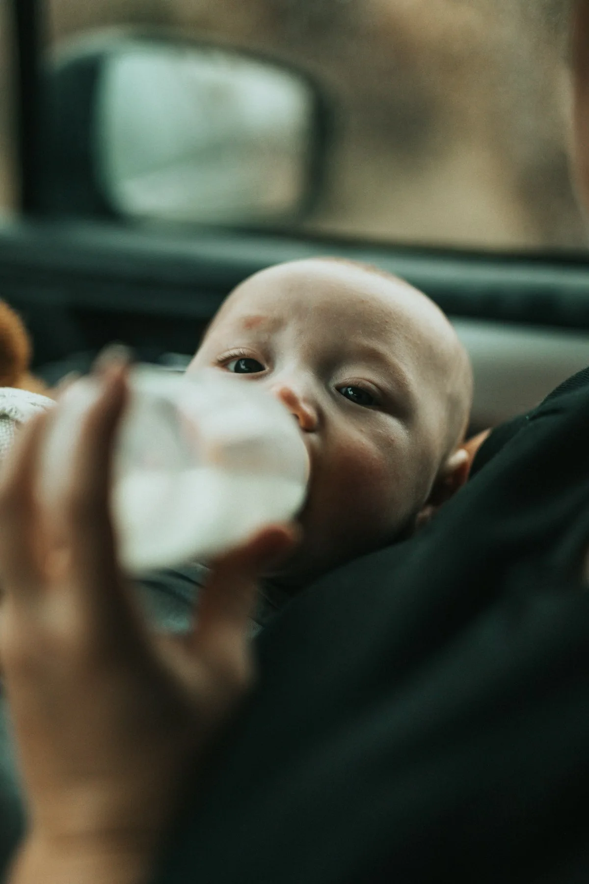 Bébé en chemise bleue buvant du lait infantile au biberon