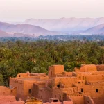 Ruelle colorée d'une médina marocaine avec des portes traditionnelles et de la lumière dorée
