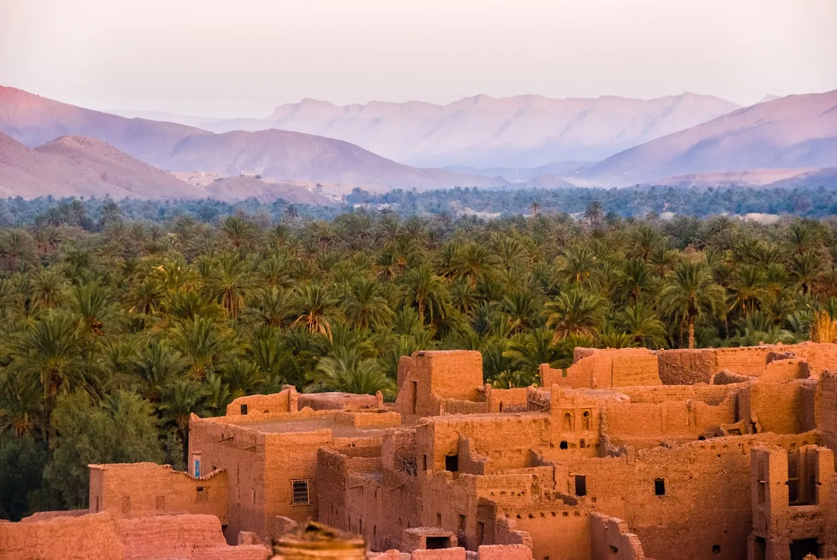 Ruelle colorée d'une médina marocaine avec des portes traditionnelles et de la lumière dorée