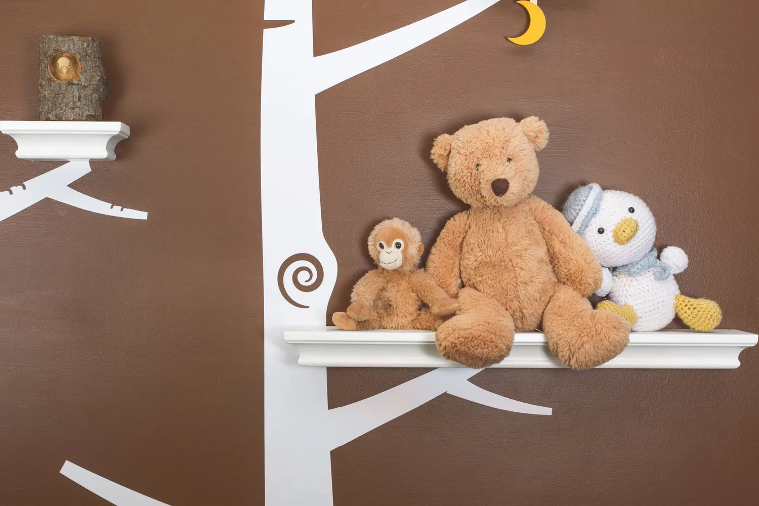 Étagère murale décorée de peluches avec un ours en peluche marron et un oiseau au crochet