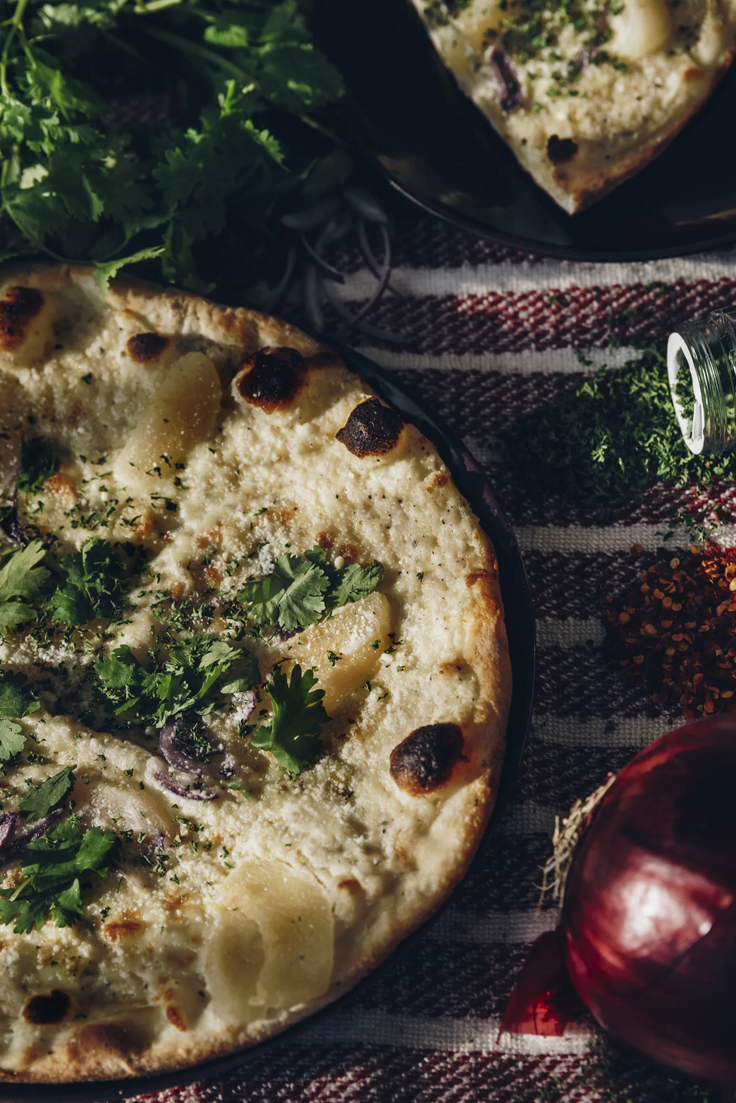 Pizza blanche aux herbes fraîches et champignons sur fond de linge à carreaux