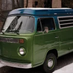 Camping-car vintage vert et bleu garé dans un paysage enneigé