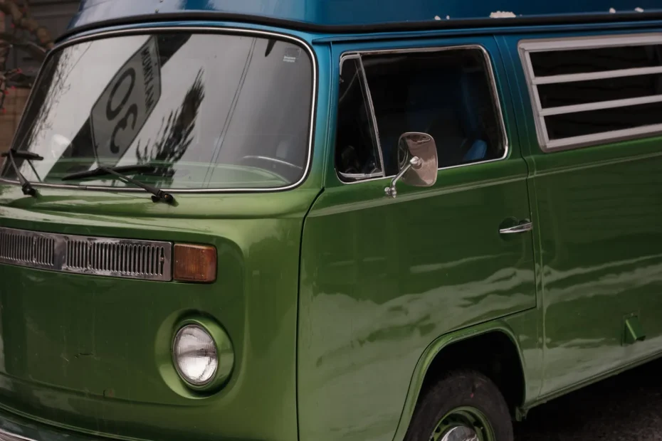 Camping-car vintage vert et bleu garé dans un paysage enneigé